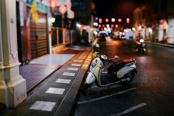 Motobike scooter parking on old town asian street at night.