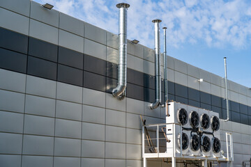 Large ventilation pipes on facade of commercial building. Outdoor split air conditioner units...