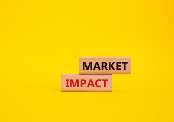 Market impact. Concept word Market impact on wooden cubes. Beautiful yellow background. Business and Market impact concept. Copy space.