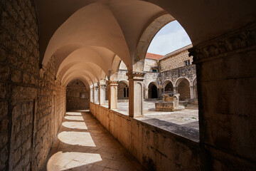Ancient catholic architecture. The courtyard of  Franciscan Monastery in Hvar, Croatia. - obrazy, fototapety, plakaty