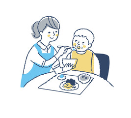 シニア女性の食事介助をしている介護スタッフ