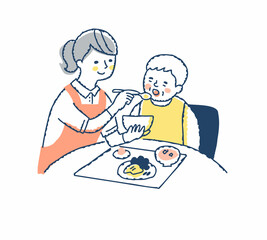 シニア女性の食事介助をしている介護スタッフ