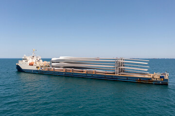 Heavy load carrier ship loaded with Electric Turbine Blades anchored at Sea, Aerial view