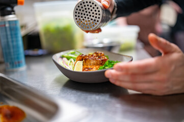chef hand cooking donburi bowl food in the restaurant kitchen