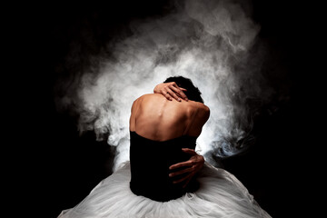 Modern ballet dancer. Ballerina posing against black with smoke in the background © Nikola Spasenoski