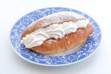 snack with sweet Maritozzo alla panna,  filled with whipped cream , still life on white background , close-up
