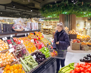 Woman buying vegetables(pepper, chili pepper, eggplant, zucchini) at the market