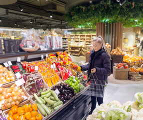 Woman buying vegetables(pepper, chili pepper, eggplant, zucchini) at the market