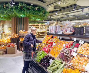 Woman buying vegetables(pepper, chili pepper, eggplant, zucchini) at the market