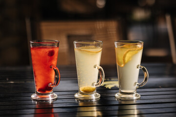 Tree different types of tea in glass cups on wooden table