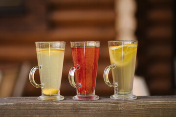 Tree different types of tea in glass cups on wooden table