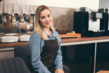 Fototapeta na wymiar Beautiful caucasian barista with coffee machine in coffee shop 
