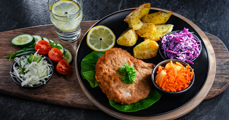 Pork cutlet coated with breadcrumbs with potatoes and salads