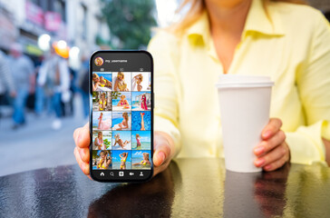Woman showing mobile phone with sample social media user photo gallery on the screen