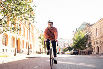 A young man riding a helmet on a bicycle to work ecotransport for the city.