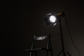 Movie directors chair on set with light on a stand.