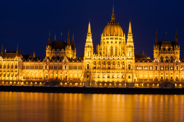 Fototapeta na wymiar Budapest parliament illuminated at night and Danube river, Hungary