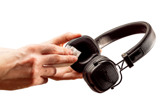 Cleaning black headphones with wet wiper isolated on white