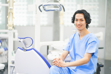 デンタルクリニックで働く若い男性歯科医師 - obrazy, fototapety, plakaty