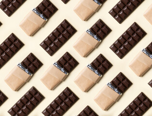 Dark chocolate bars, cocoa, handmade, with and without wrapper, arranged in a repeating pattern, on beige plain background. Studio photography