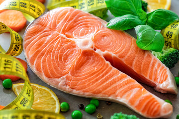 Fresh raw salmon steak with vegetables and measuring tape. Diet, dietary food concept