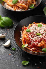 Italian marinara sauce spaghetti pasta served with fresh basil, olives and pecorino cheese