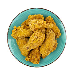 Fried chicken wings on a plate, isolated on white, top view