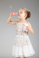 little girl making foam balloons, studio shot