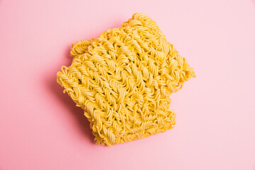 Flatlay, paper background with copy space. Two large servings of instant noodles on a pink background.