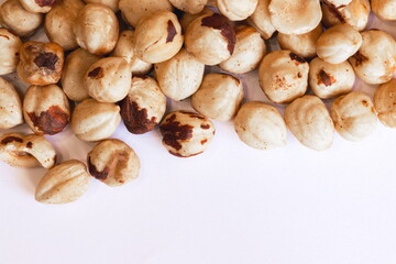 Peeled hazelnuts on a white background. Poorly peeled hazelnuts.