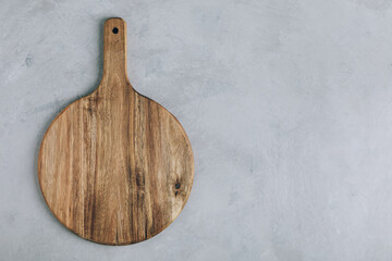 Chopping board. Empty round wooden cutting board on gray stone background, top view, copy space.