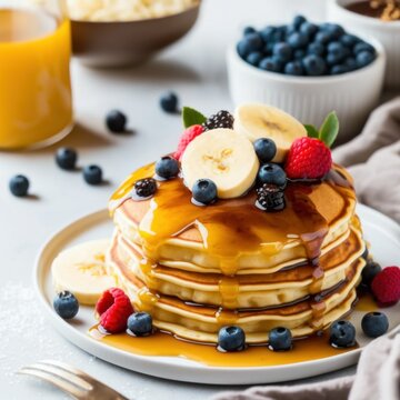 Breakfast set of pancakes with syrup and fresh berries and bananas on a white table. Created using generative AI and image editing software.