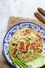 Somtum, Thai spicy papaya salad on white background, international Thai food Known and popular, made with papaya and tomatoes, it tastes sour, sweet and spicy.