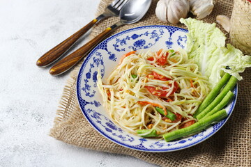 Somtum, Thai spicy papaya salad on white background, international Thai food Known and popular, made with papaya and tomatoes, it tastes sour, sweet and spicy.