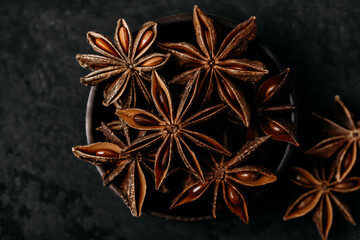 Anise. Star anise in a wooden bowl dark stone background