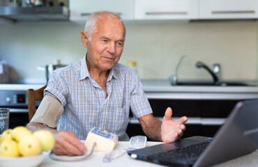 Man having video call with doctor, using laptop at home