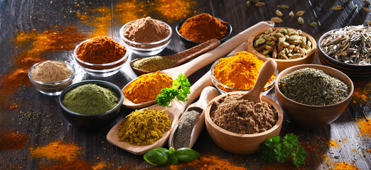 Variety of spices on wooden kitchen table.