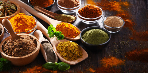 Variety of spices on wooden kitchen table.