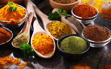 Variety of spices on wooden kitchen table.