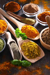 Variety of spices on wooden kitchen table.