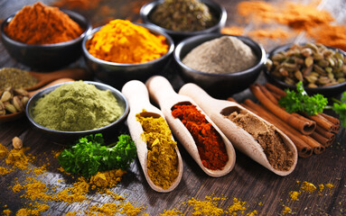 Variety of spices on wooden kitchen table.