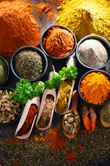 Variety of spices on wooden kitchen table.