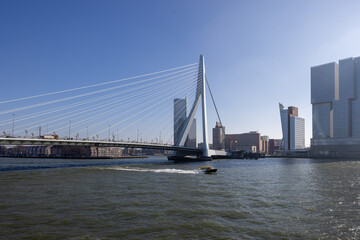 The Erasmus Bridge in Rotterdam - The Netherlands with the head of south and a watertaxi