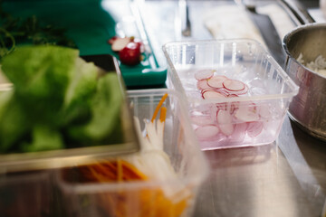 Preparing vegetables for a delicious bowl dish: a male chef in a contemporary restaurant kitchen.