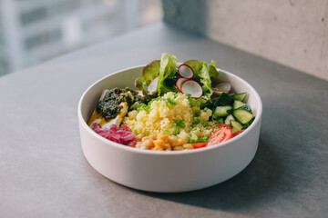 Poke bowl with vegetables and cheese.