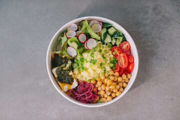 Poke bowl with vegetables and cheese.
