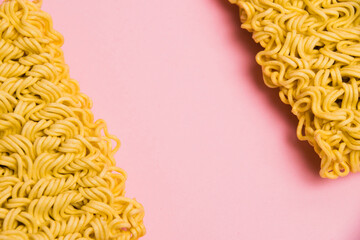 Flatlay, paper background with copy space. Two large servings of instant noodles on a pink background.
