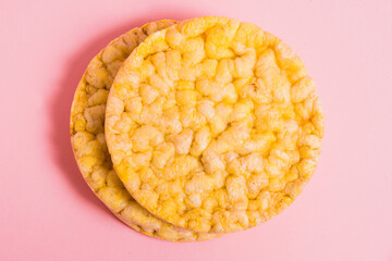 Flatlay, crispy, diet cornbread on a pink background.