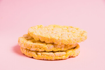 Tasty, crispy, diet cornbread on paper pink background, side view. Delicious diet food.