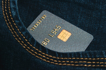 Bank card with a modern chip in the pocket of jeans. Concept of safe online operations with bank accounts and protection of bank cards from fraudsters